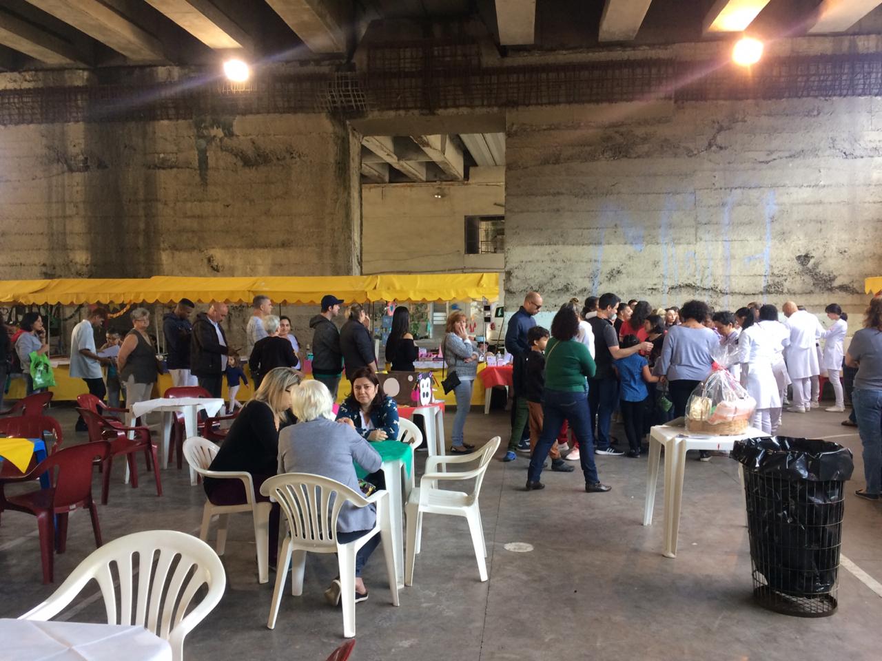 Espaço da ação embaixo do viaduto da Lapa mostra população em fila para vacinação e munícipes sentados na praça de alimentação do evento 